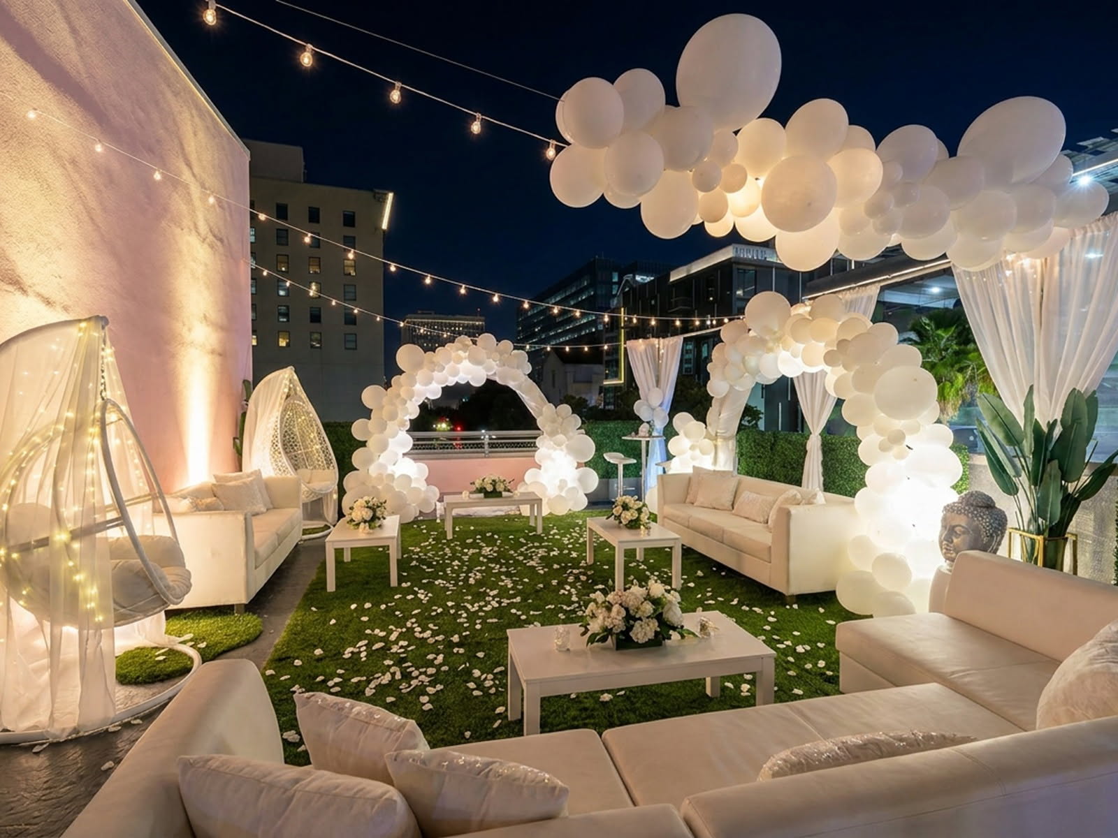 Rooftop ceremony lounge at night with balloon arches and string lights