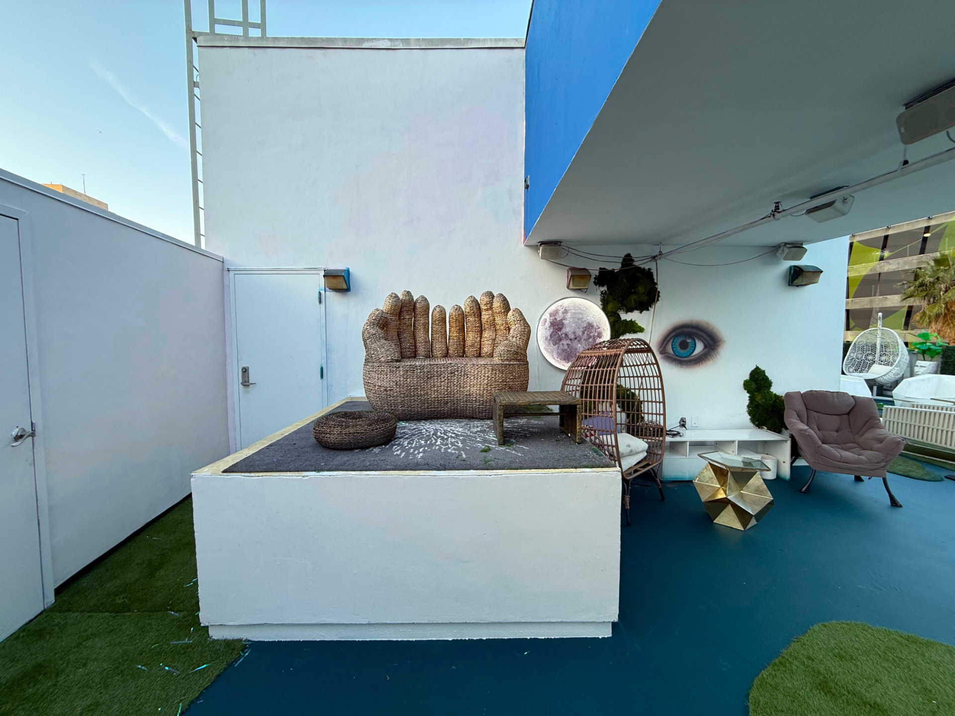 The woven hand-shaped sofa and moon light on the rooftop in daylight