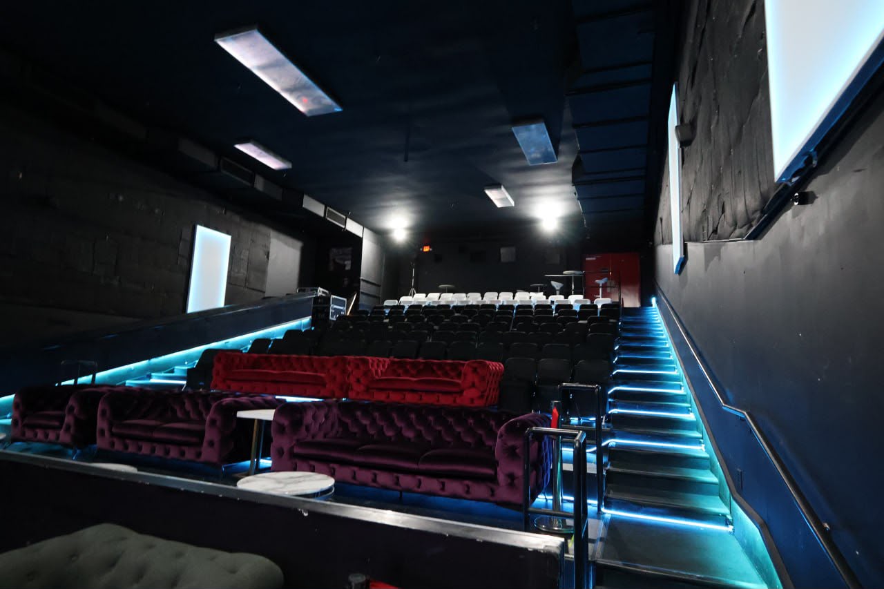 Theater seating with velvet sofas under blue LED floor lighting